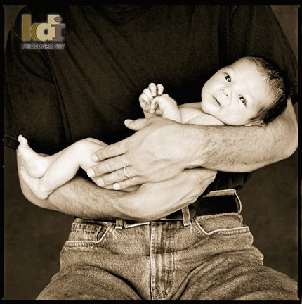 9 day old newborn in his father's arms