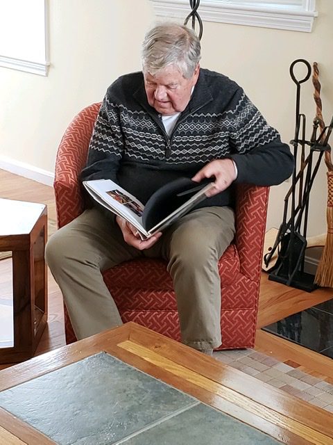 Grandfather enjoys family photo album with family memories and history in portraits, by Flagstaff photographer, KDI Photography