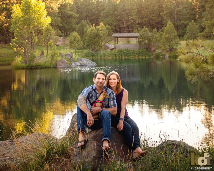 Portrait of Couple Sitting By Pond in Flagstaff AZ, Holding Their Dog