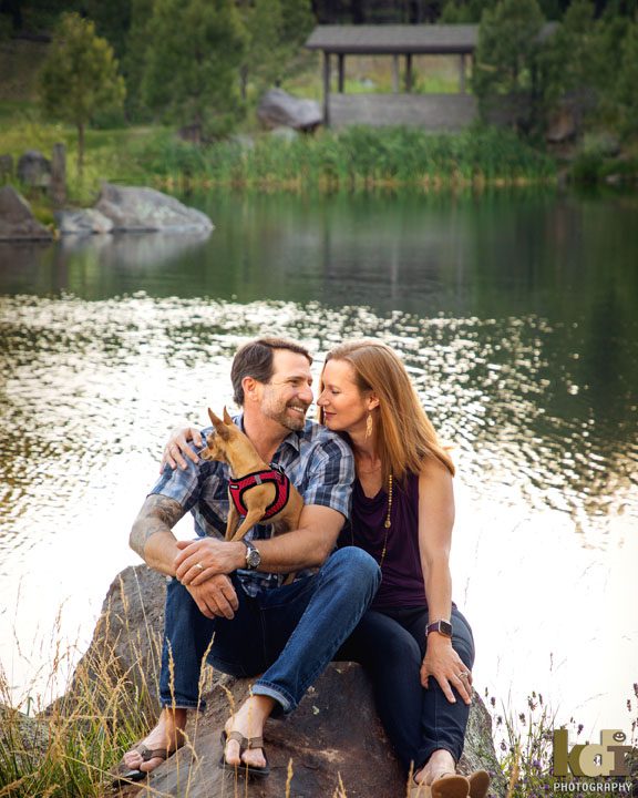 Portrait of Couple Sitting By Pond in Flagstaff AZ, Holding Their Dog