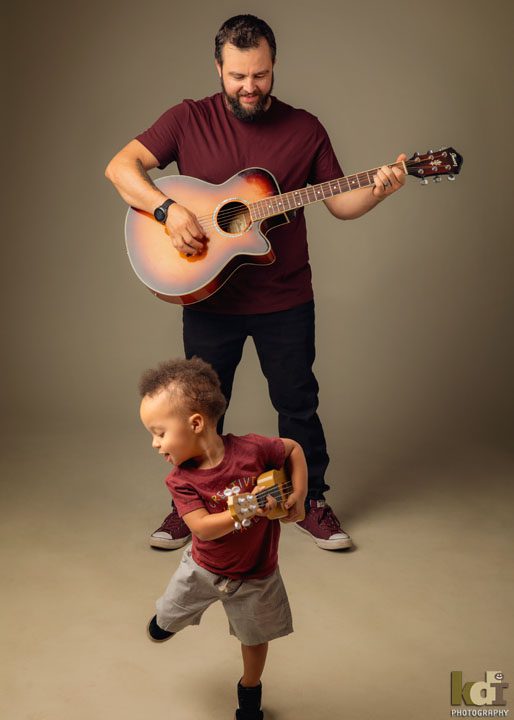 father and son music lesson with guitar and ukulele