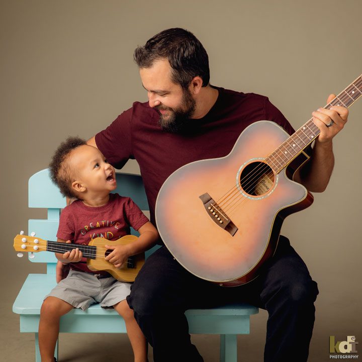 father and son music lesson with guitar and ukulele