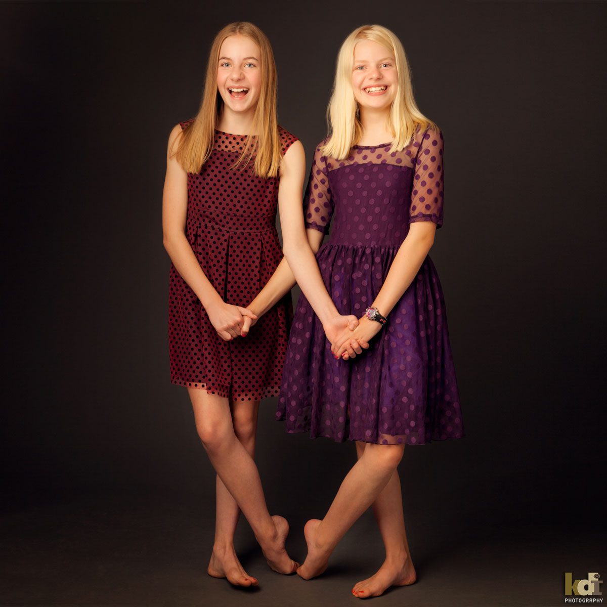 Color studio portrait of sisters holding hands in dresses, by Flagstaff photographer.