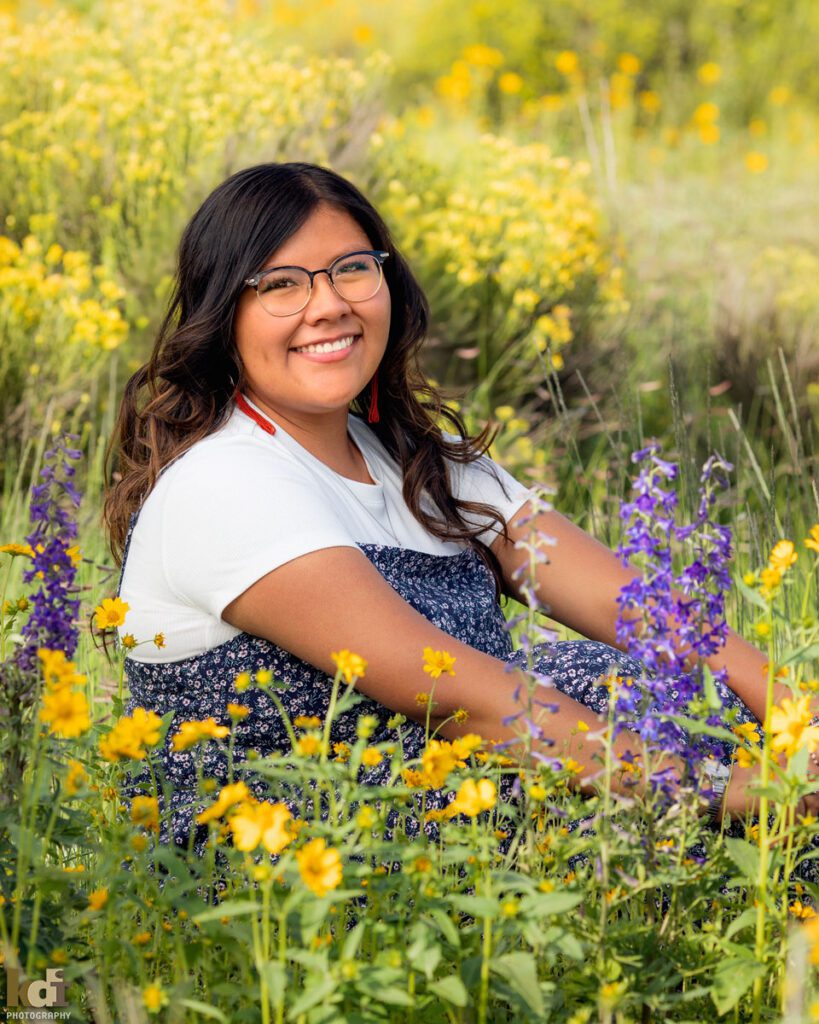 Senior portrait of girl sitting in yellow and purple flowers, near the San Francisco Peaks, in Northern Arizona, Coconino County, Flagstaff AZ. ©KDI Photography