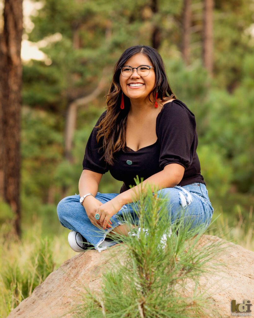 Senior portrait of smiling girl sitting in the ponderous pine forest, near the San Francisco Peaks, Coconino County, Northern Arizona, Flagstaff AZ. ©KDI Photography
