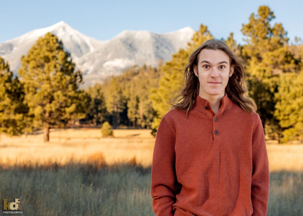 senior in high school shows his startle face in front of the San Francisco Peaks in Flagstaff Arizona. © KDI Photography
