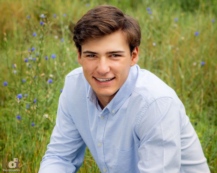 High school senior boy in blue shirt in Flagstaff, AZ. Senior photos by KDI Photography.