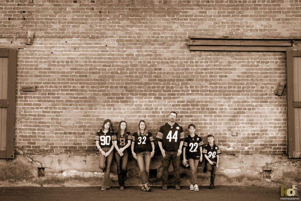 Portrait of family of six, posing very seriously in their Pittsburgh Steelers shirts, Downtown Flagstaff, AZ Portraits by KDI Photography