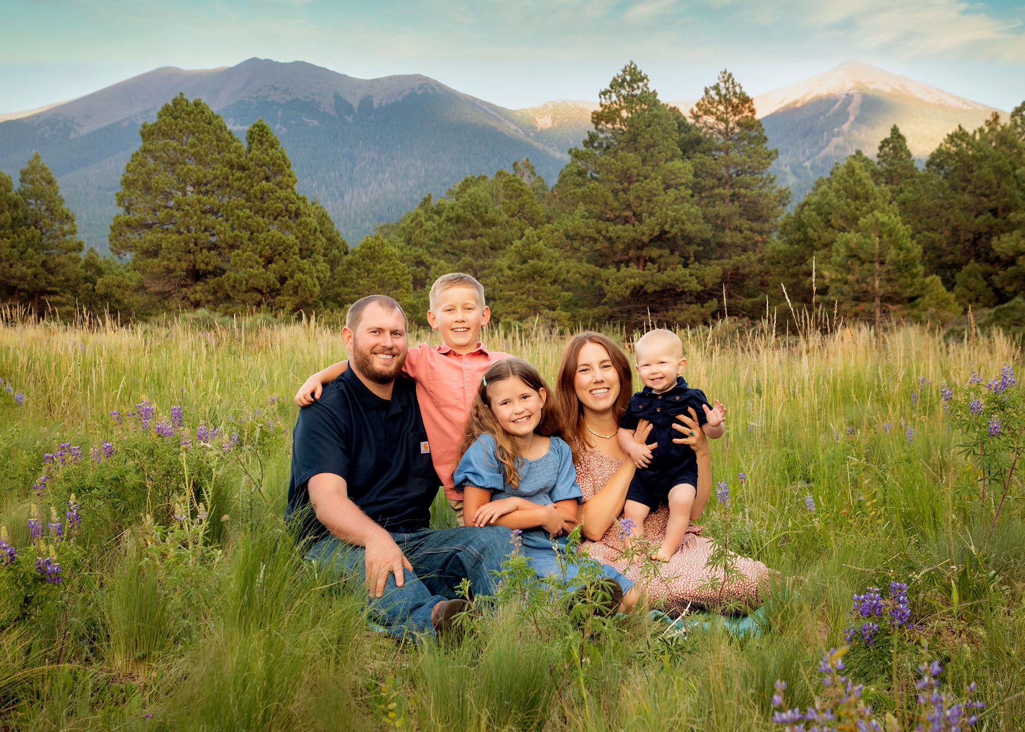 Family of Fiver, Smiling, Sitting in the Grass and Summer Flowers, with the San Francisco Peaks Behind them in Beautiful Flagstaff, AZ, by KDI Photography