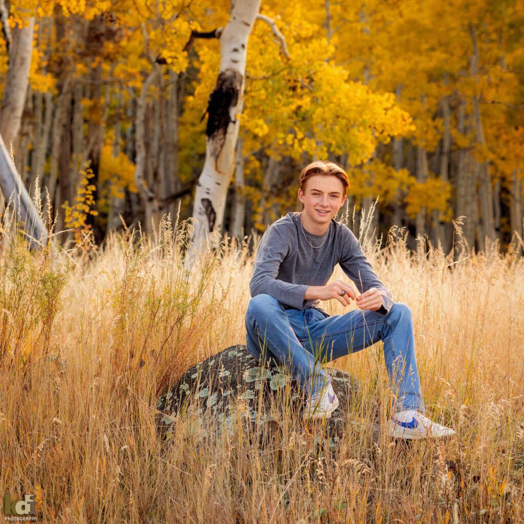High School Senior Boy, Sitting on Rock in Fall Aspen Trees, Senior Photos in Flagstaff, AZ by KDI Photography, Senior Photographer