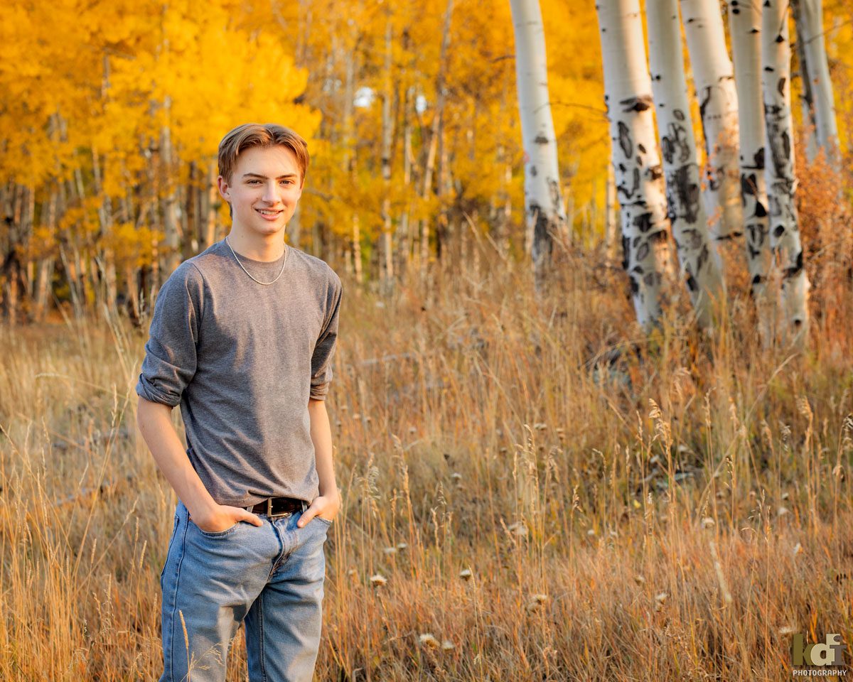 High School Senior Boy, Standing in Grass in Colorful Fall Aspen Trees, Senior Photos in Flagstaff, AZ by KDI Photography, Senior Photographer