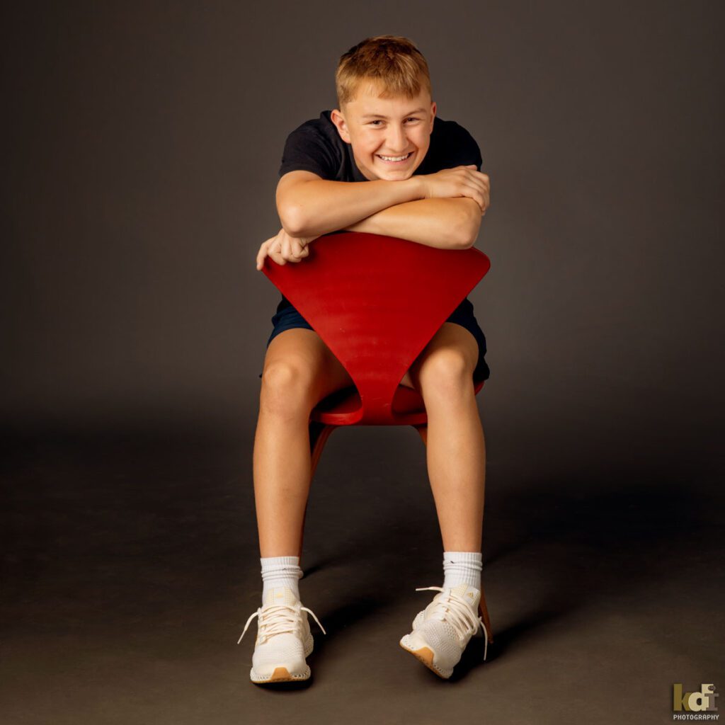 Teen Boy Laughing on Red Chair, Family and Kids Portrait Photographer in Flagstaff, AZ by KDI Photography 