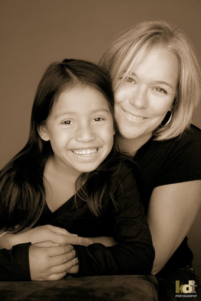 Black and white portrait of a mother, snuggling her giggling tween preteen daughter, studio family pictures in Northern Arizona, family photographs by KDI Photography
