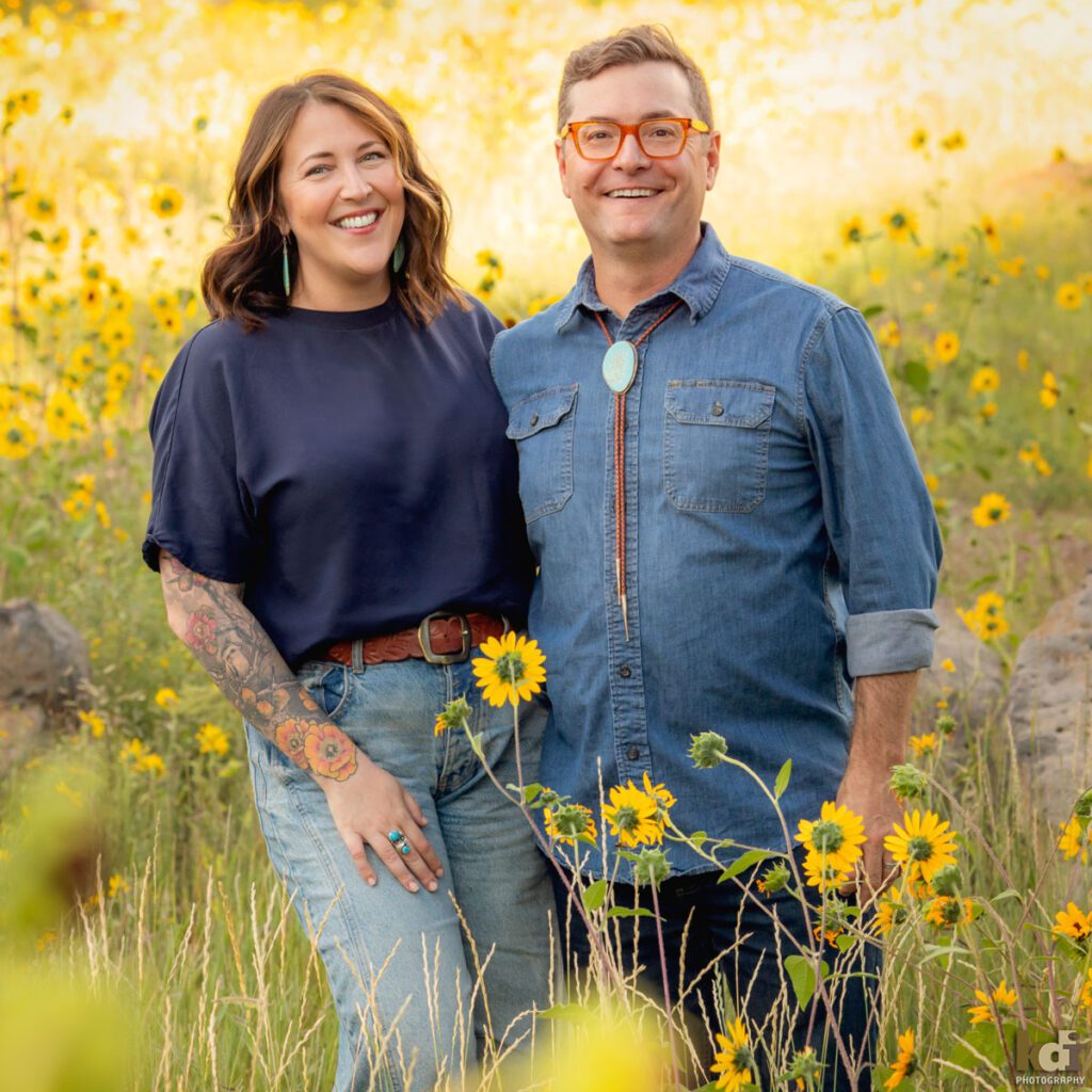 A family photo session in a field of flowers with a husband and wife laughing in Flagstaff Arizona, location portraits by KDI Photography