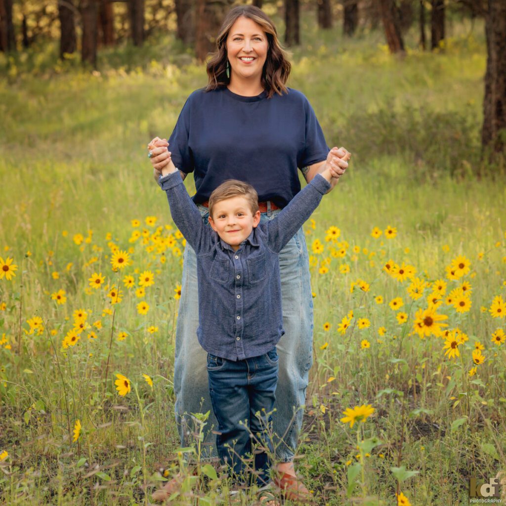 A family photo session in a field of flowers with a mother and son laughing in Flagstaff Arizona, location portraits by KDI Photography
