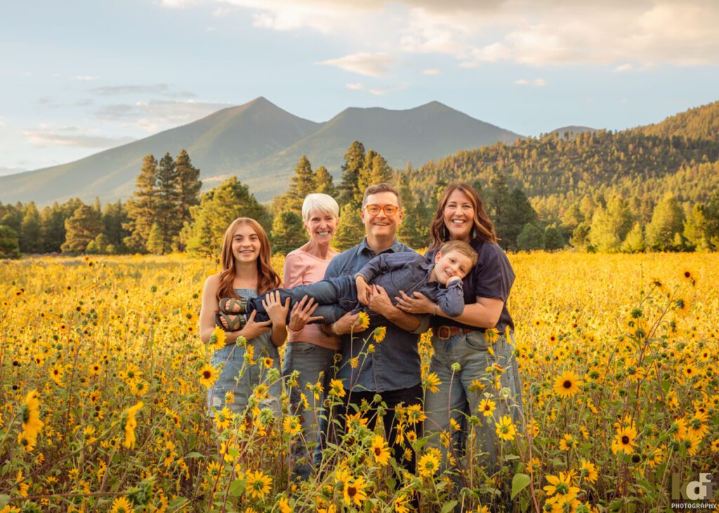 A family photo session in a field of flowers and the San Francisco Peaks, with three generations in Flagstaff Arizona, location portraits by KDI Photography