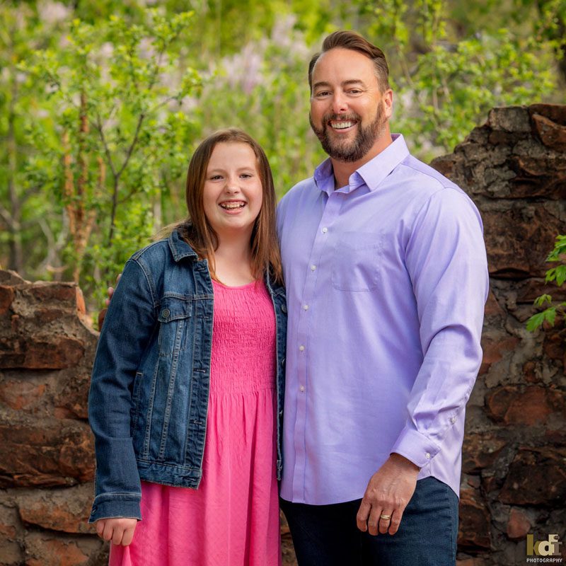 Portrait of father and preteen tween daughter, laughing while looking at the camera in Sedona AZ, photographic art by KDI Photography.