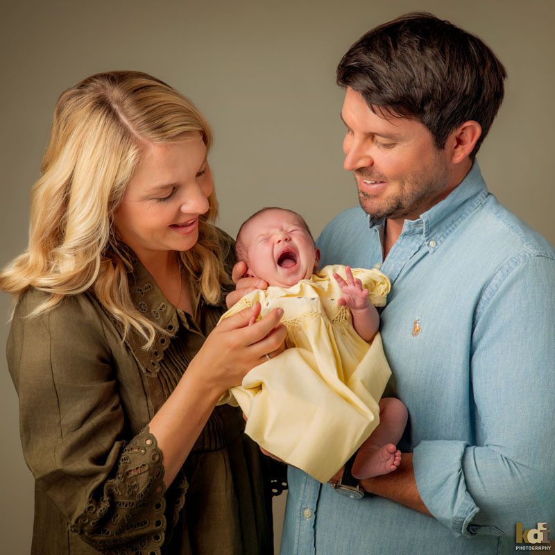 Family photos of a two parents snuggling a newborn who is yawning, studio portraits in Northern Arizona, family portraits by KDI Photography
