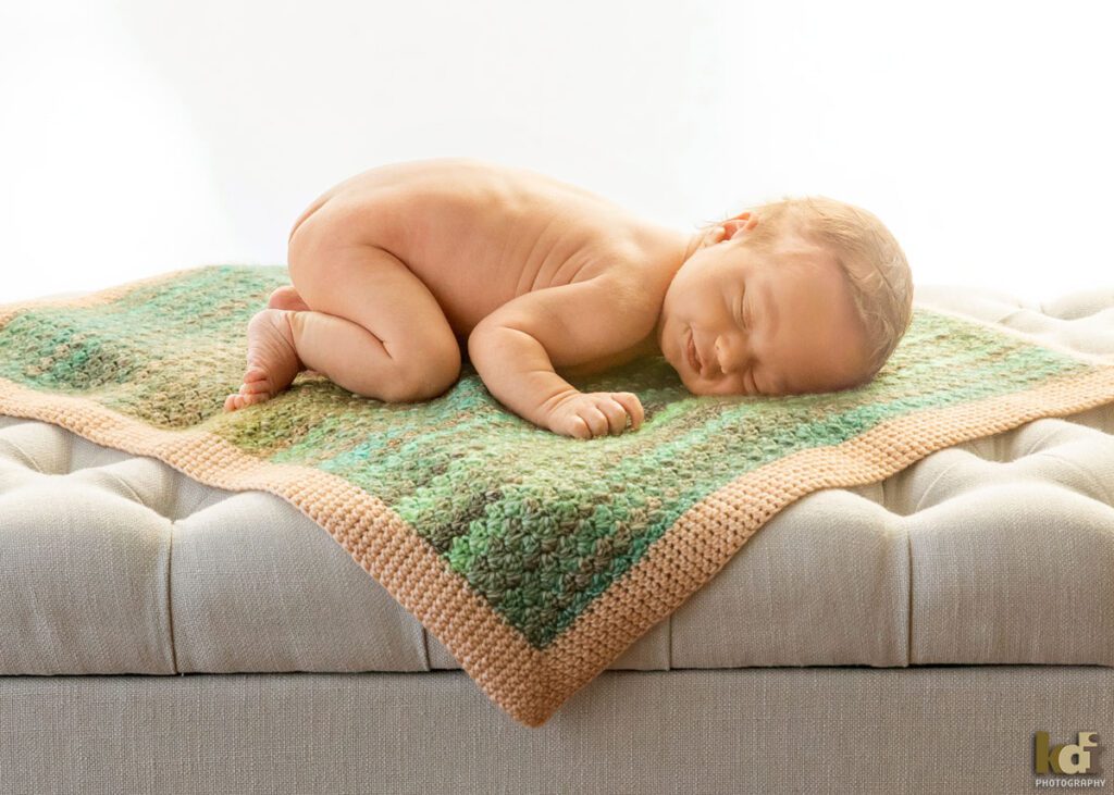 Color newborn photography, portrait of a new baby boy, , asleep, smiling, lying on blanket in a photo studio in Flagstaff by newborn and family photographer, KDI Photography
