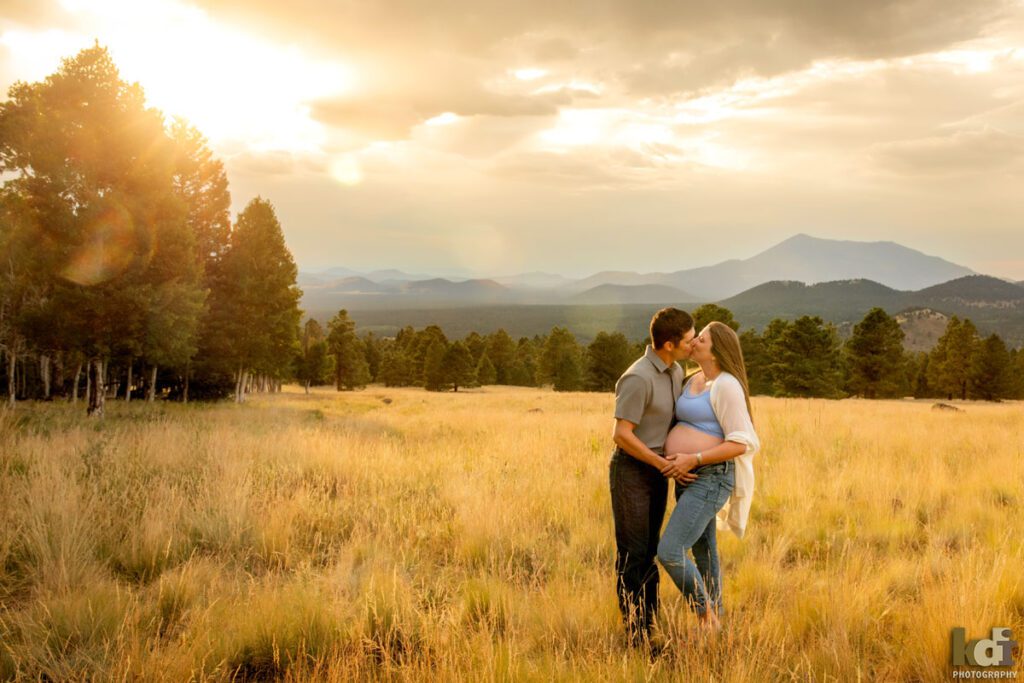 Maternity photo, portrait of a pregnant couple kissing, on location at the Arizona Snowbowl, in the San Francisco Peaks, by Flagstaff pregnancy photographer, KDI Photography
