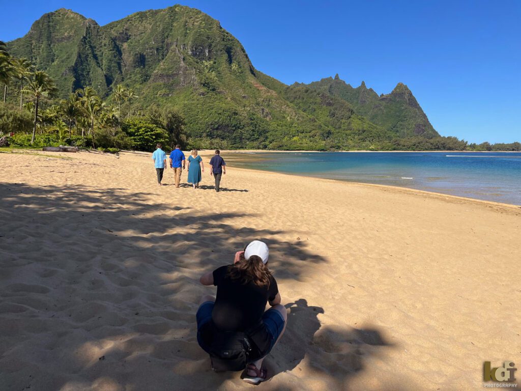 Behind the scenes of a family portrait of a husband, wife and two teen boys, walking away on a beach in Hawaii, location family photos by Flagstaff photographers KDI Photography.