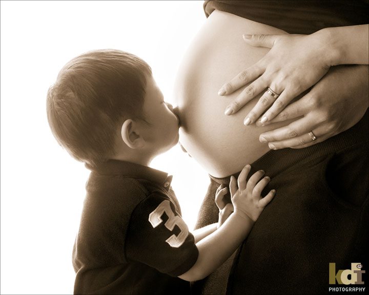 black & white pregnancy portrait, big brother kisses mother's belly, maternity photography by Flagstaff photographers KDI Photography