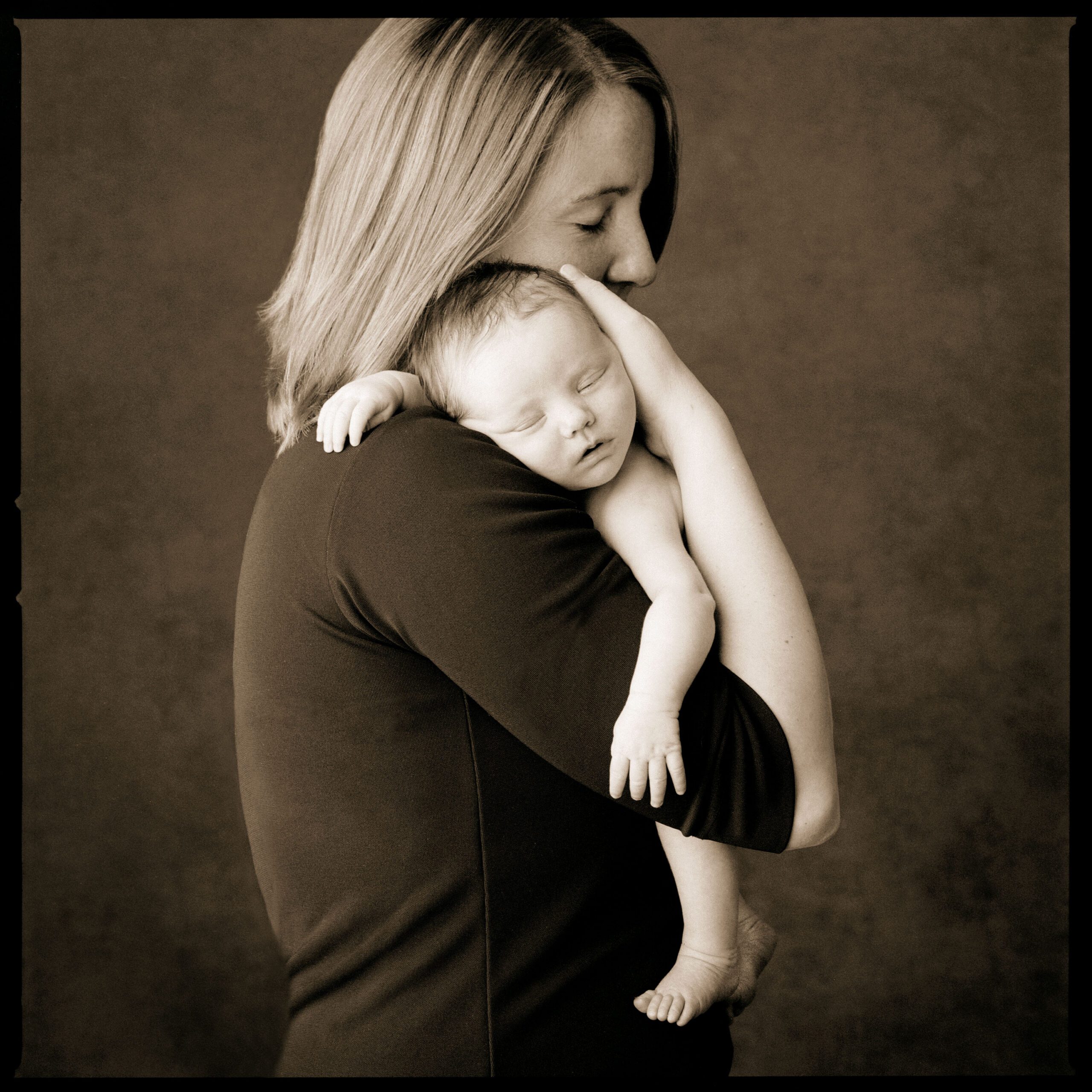 Mother hugs her adult daughter in a black and white studio family photo, portrait art by Flagstaff photographer, KDI Photography