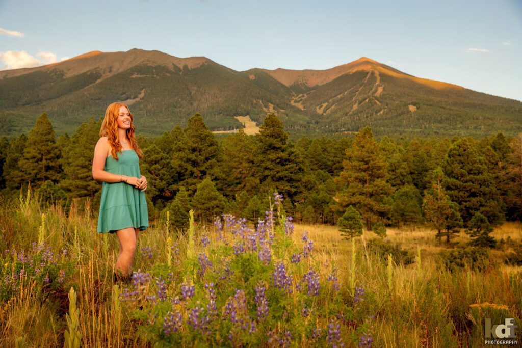 High school senior photos showing girl with red hair, in front of the San Francisco Peaks of Northern Arizona, portrait photography in Flagstaff AZ by senior photographer KDI Photography